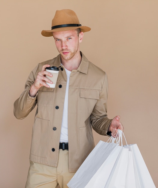 Kostenloses Foto mann mit weißen einkaufstüten und kaffee