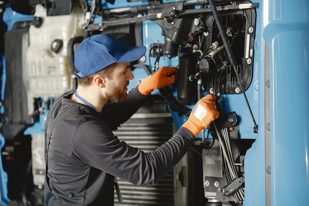 Mann mit Werkzeugen für LKW. Arbeiter in Uniform. Fehlerhafter LKW