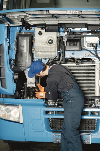 Mann mit Werkzeugen für LKW. Arbeiter in Uniform. Fehlerhafter LKW