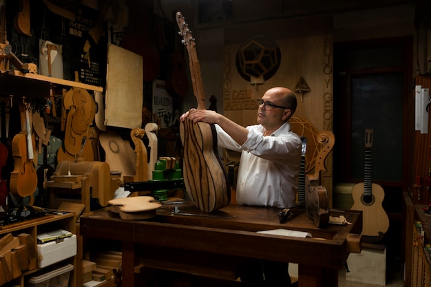 Mann mittleren Alters, der allein in seiner Werkstatt Instrumente herstellt