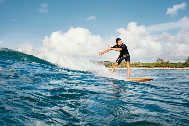 Mann reitet sein Surfbrett und hat eine gute Zeit Long Shot