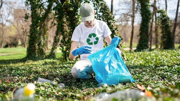 Mann sammelt Plastikmüll in einem verschmutzten Park