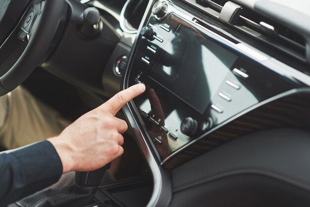 Mann schließt ein Audiosystem in das Auto ein.