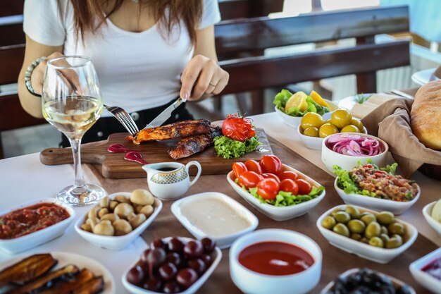 Mann schneiden gegrillte Forelle Oliven Tomaten Mangal Salat Auberginen Seitenansicht