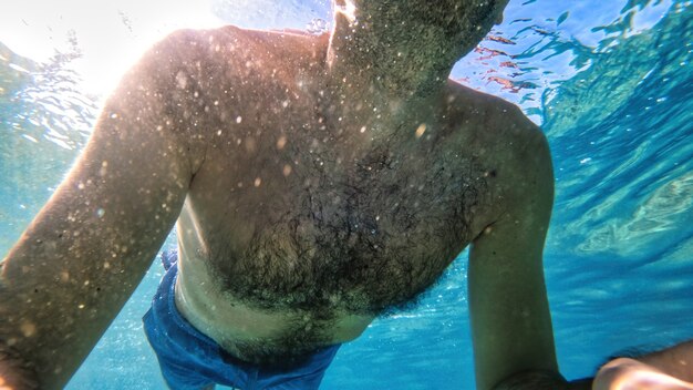 Mann schwimmt im Wasser des Mittelmeers