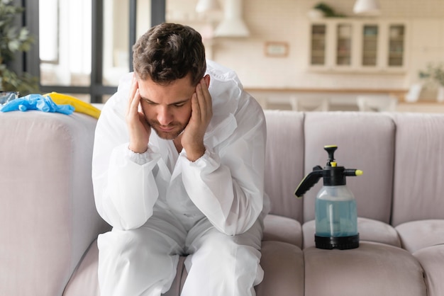 Mann sitzt auf der Couch mit Kopfschmerzen