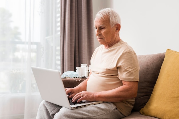 Mann sitzt auf der Couch mit Laptop