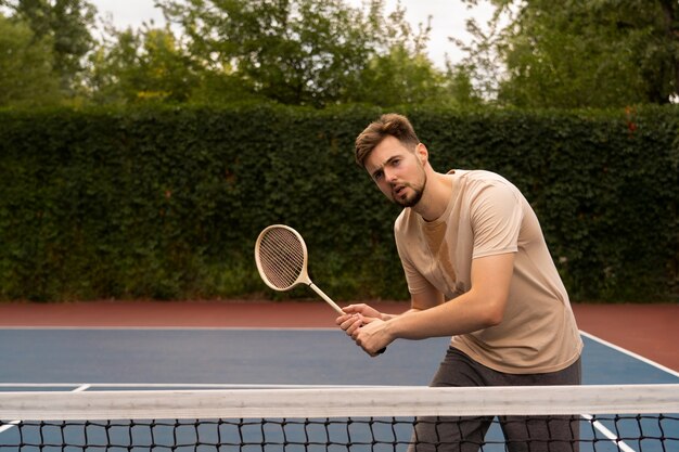 Mann spielt Badminton mittlerer Schuss