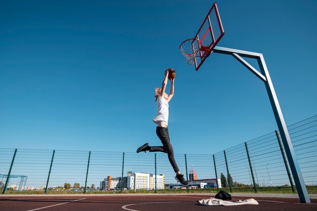 Mann spielt Basketball voller Schuss