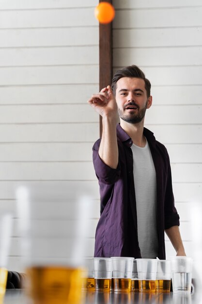 Mann spielt Bierpong auf einer Indoor-Party