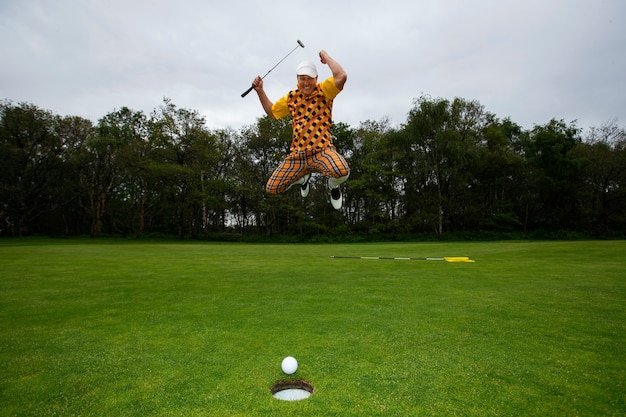 Kostenloses Foto mann spielt draußen auf dem golfplatz eine partie golf