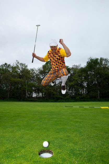 Kostenloses Foto mann spielt draußen auf dem golfplatz eine partie golf