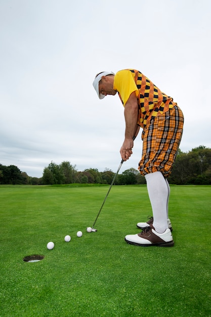 Kostenloses Foto mann spielt draußen auf dem golfplatz eine partie golf