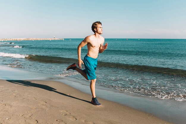 Mann sprinkt am Strand