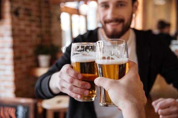 Mann stößt mit einem Freund in der Bar an