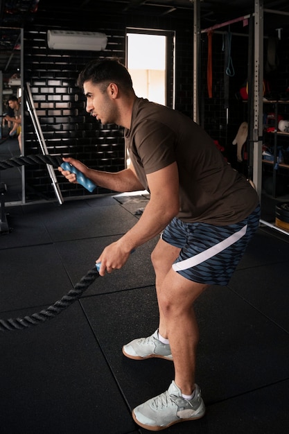 Mann trainiert im Fitnessstudio Seitenansicht