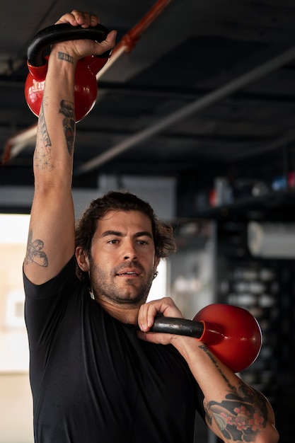 Kostenloses Foto mann trainiert in der vorderansicht des fitnessstudios