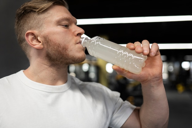 Kostenloses Foto mann trinkt getränk im fitnessstudio