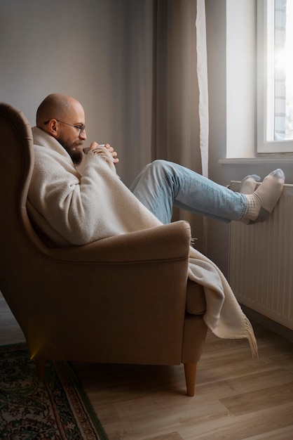 Kostenloses Foto mann trinkt heißes getränk während der energiekrise