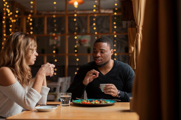 Mann und Frau, die am Restaurant essen