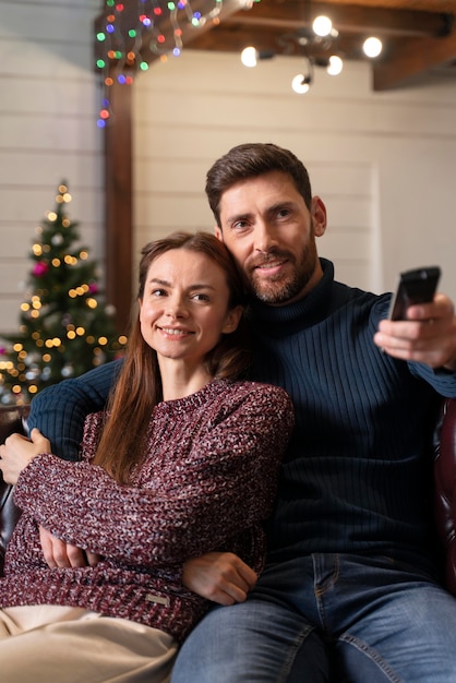 Kostenloses Foto mann und frau, die an weihnachten fernsehen