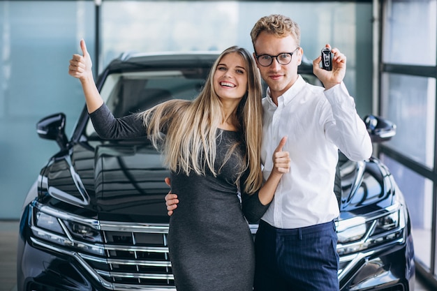 Mann und Frau, die ein Auto in einem Autosalon wählen