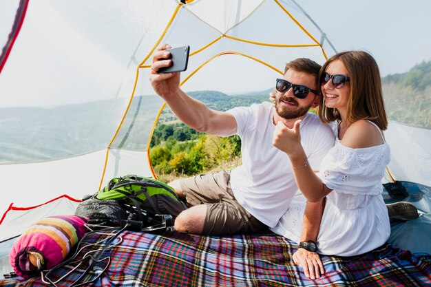 Mann und Frau, die ein Selbstfoto im Zelt machen