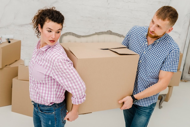 Mann und Frau, die großen Kasten tragen