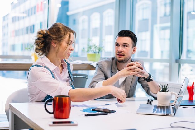 Mann und Frau, die im Büro sprechen