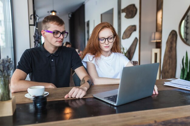 Mann und Frau, die Laptopbildschirm betrachten