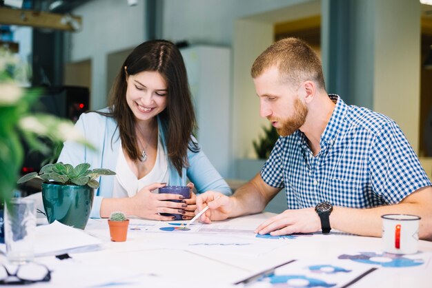 Mann und Frau, die zusammen an Diagrammen arbeiten