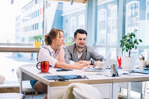 Mann und Frau, die zusammen an Laptop arbeiten