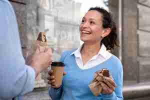 Kostenloses Foto mann und frau genießen essen zum mitnehmen auf der straße