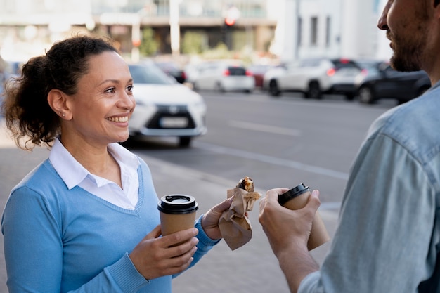 Mann und Frau genießen Essen zum Mitnehmen auf der Straße