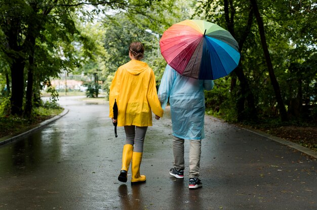 Mann und Frau machen einen Spaziergang unter dem Regen