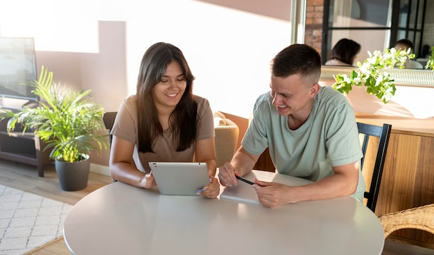 Mann und Frau machen Einkaufsliste mit Tablet