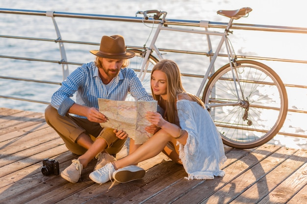 Mann und Frau mit blondem Haar Boho Hipster-Stil Mode, die Spaß zusammen haben, in der Karte Sightseeing suchen