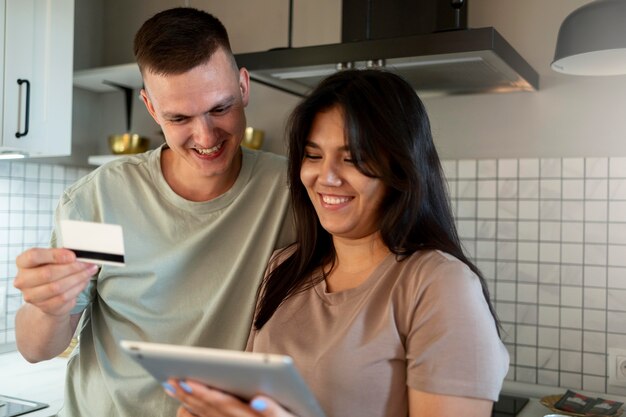 Mann und Frau mit Tablet für Online-Shopping mit Kreditkarte