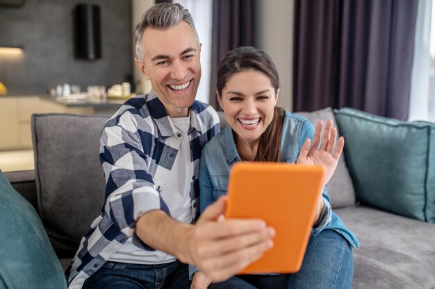 Mann und Frau schauen auf Tablet