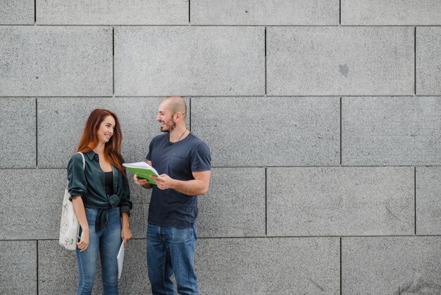 Mann und Frau stehen gegen graue Wand