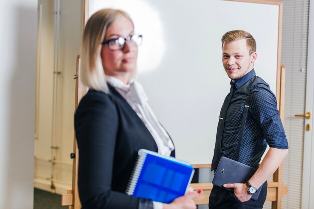 Mann und Frau stehen gegen Whiteboard