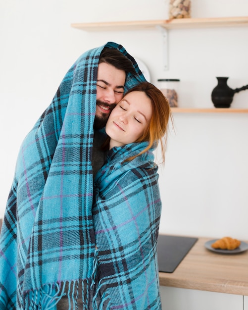 Kostenloses Foto mann und frau umarmen sich in einer decke