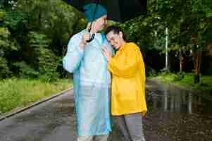 Kostenloses Foto mann und frau umarmen sich unter dem regenschirm