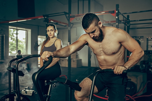 Mann und Frau während der Übungen im Fitnessstudio.