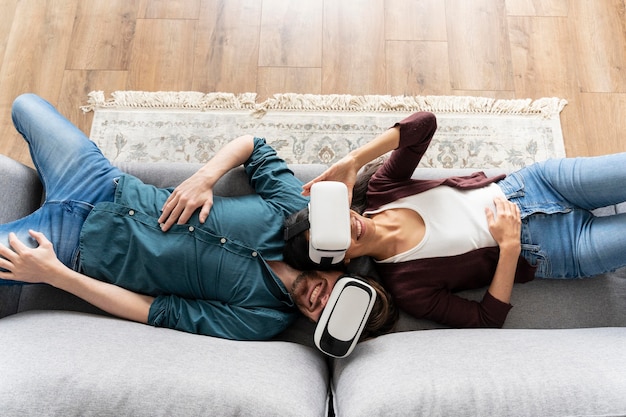 Mann und frau zu hause auf der couch mit virtual-reality-headset
