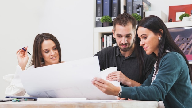 Mann und Frauen mit Plan im Büro