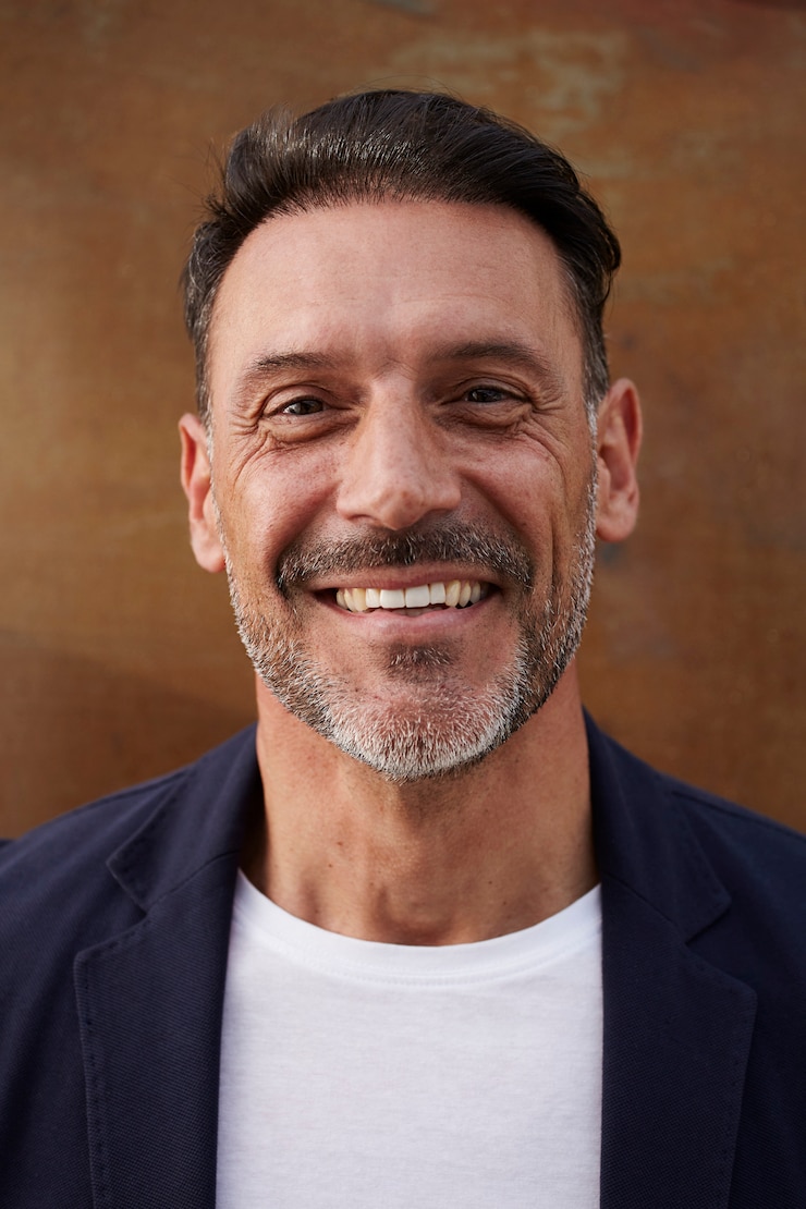 Kostenlose Foto mann von mittlerem alter, der ein jackenlachen glücklich trägt