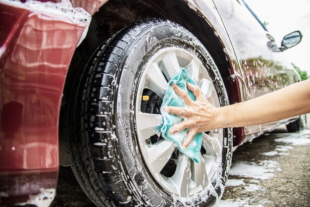 Mann waschen Auto mit Shampoo