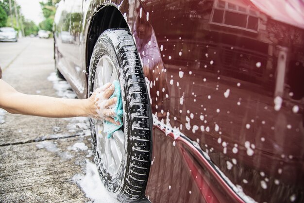 Mann waschen Auto mit Shampoo
