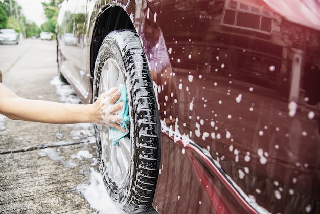 Mann waschen Auto mit Shampoo